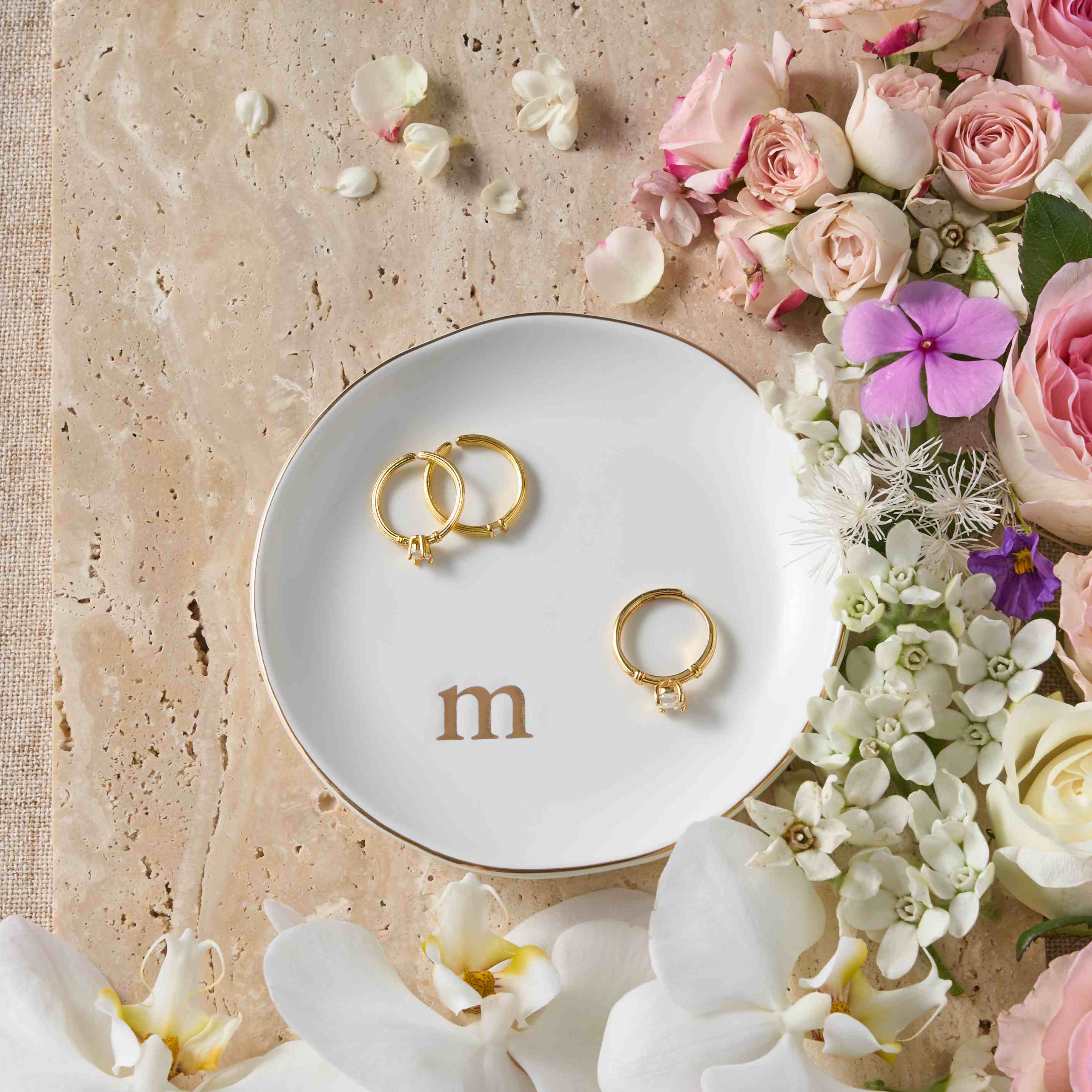 The Lolalet monogrammed trinket tray placed on a white vanity, holding a delicate necklace next to a bottle of perfume.