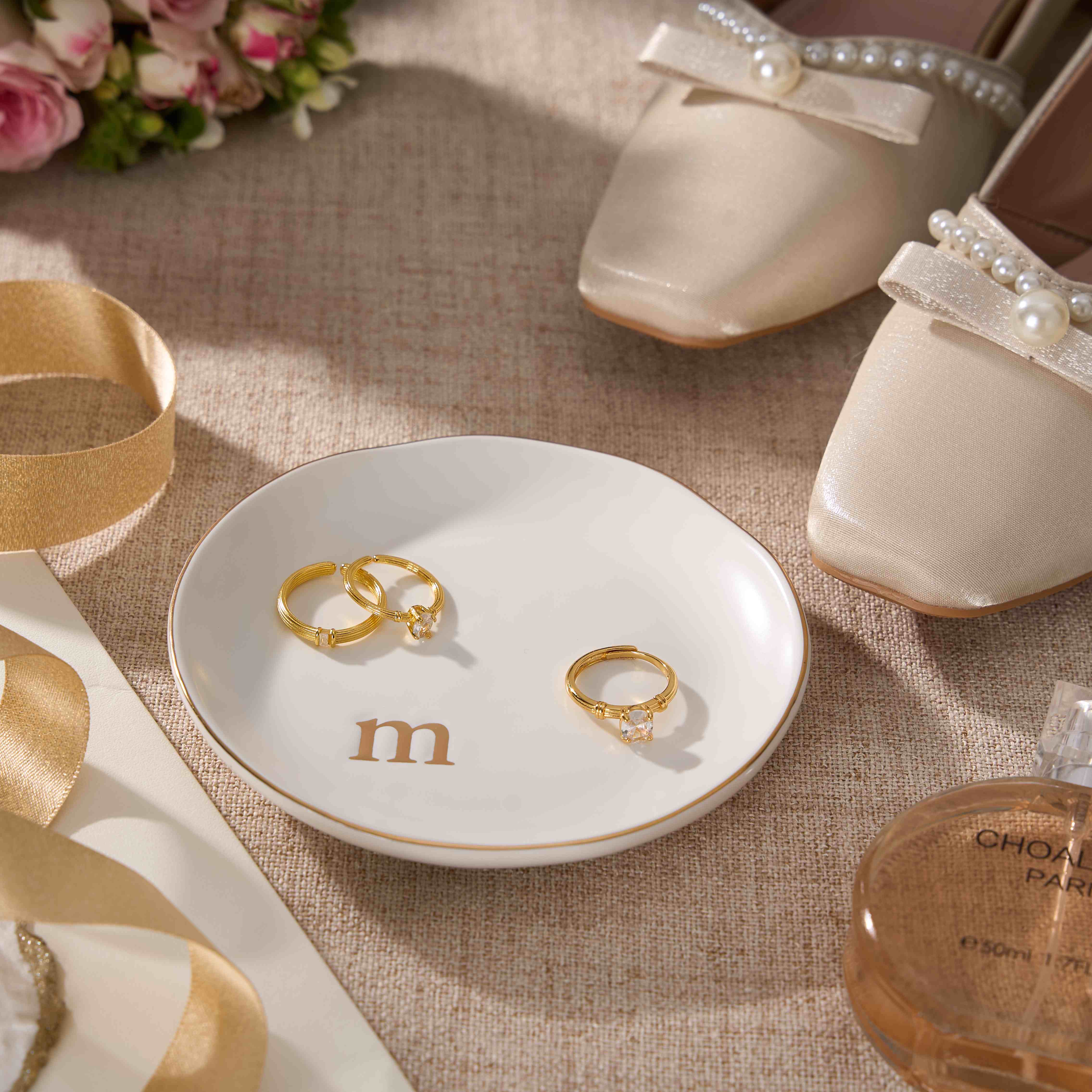 A Lolalet initial "S" jewelry dish sitting on a wooden nightstand, keeping rings and earrings safe and organized overnight.