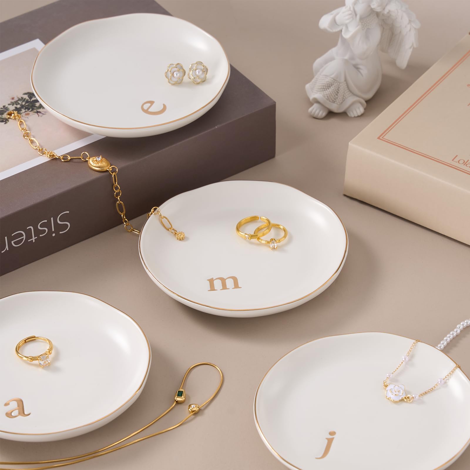 A Lolalet white ceramic jewelry dish featuring a gold "n" initial, elegantly holding an engagement ring, serving as a monogrammed ring holder.
