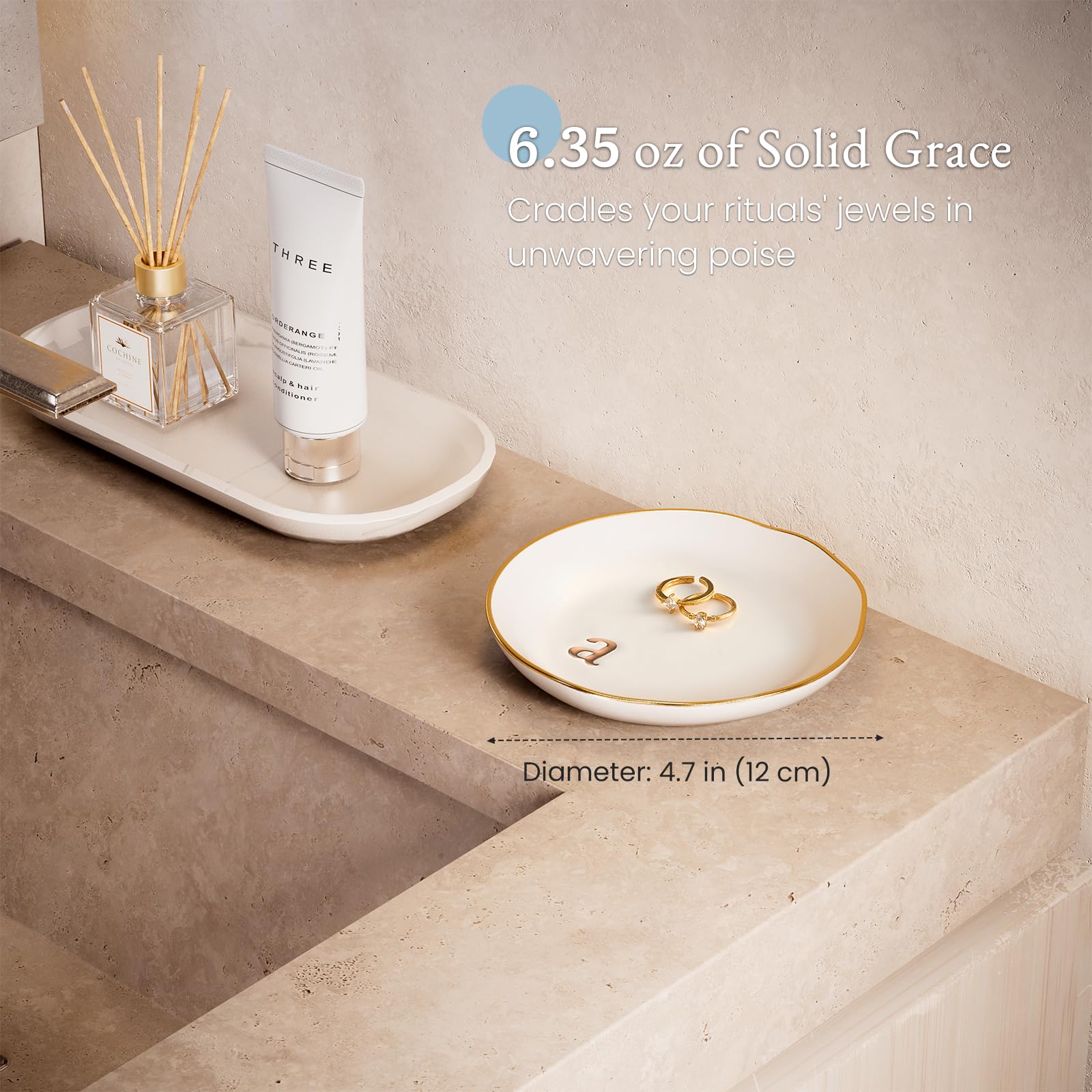 A Lolalet white ceramic jewelry dish featuring a gold "n" initial, elegantly holding an engagement ring, serving as a monogrammed ring holder.