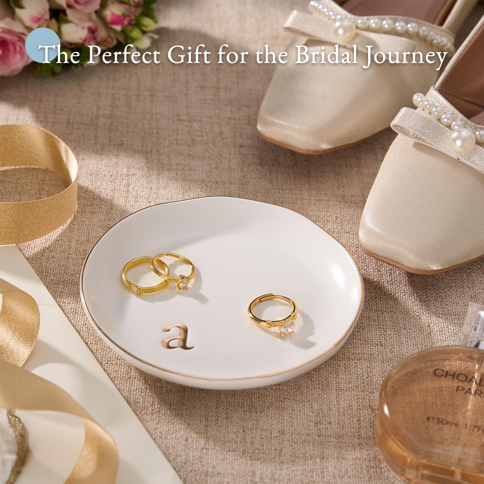 A Lolalet white ceramic jewelry dish featuring a gold "n" initial, elegantly holding an engagement ring, serving as a monogrammed ring holder.