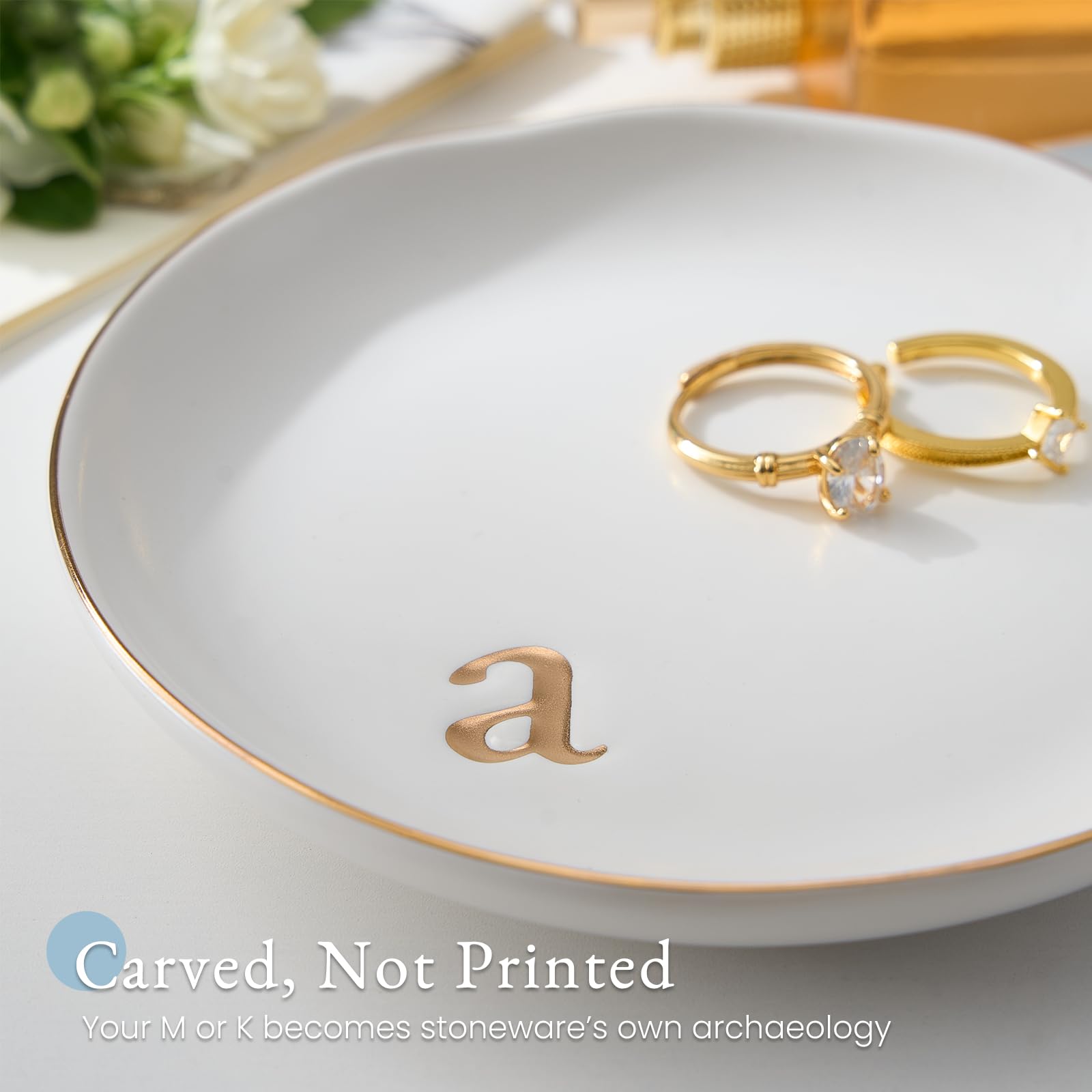 A Lolalet white ceramic jewelry dish featuring a gold "n" initial, elegantly holding an engagement ring, serving as a monogrammed ring holder.