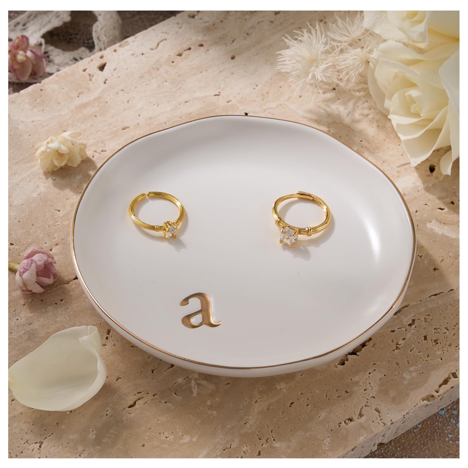 A Lolalet white ceramic jewelry dish featuring a gold "n" initial, elegantly holding an engagement ring, serving as a monogrammed ring holder.
