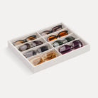 Lolalet 8-grid velvet sunglasses organizer tray displayed on a dresser, neatly holding various styles of men's and women's eyewear.