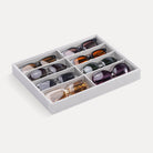 Lolalet 8-grid velvet sunglasses organizer tray displayed on a dresser, neatly holding various styles of men's and women's eyewear.