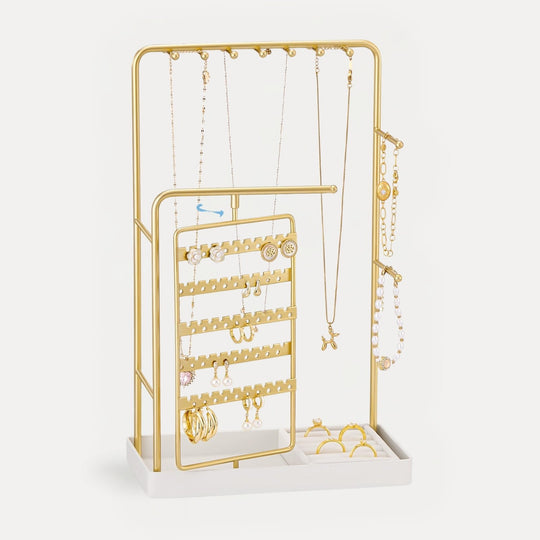 A Black rotating jewelry organizer tower displaying a full collection of earrings, necklaces, bracelets, and rings.